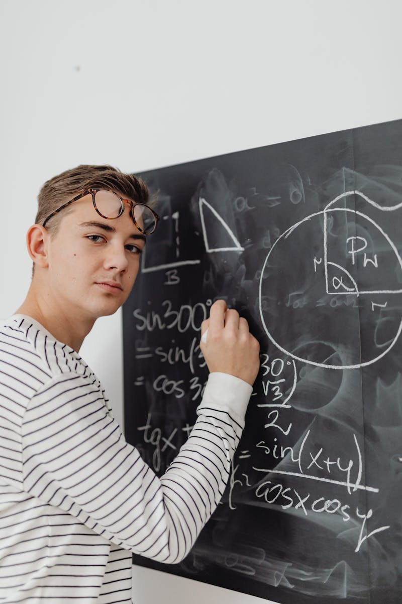 Portrait of a Boy Solving a Mathematical Equation on a Blackboard
